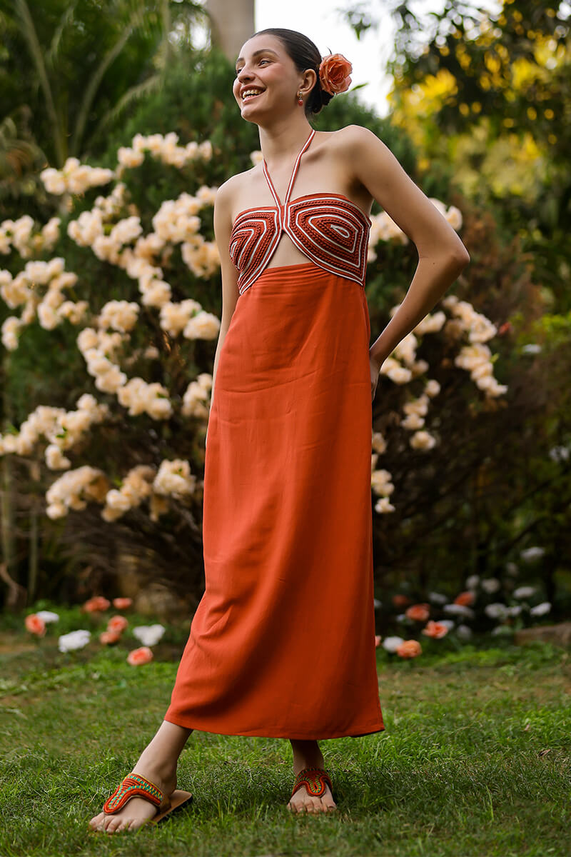 Woman in an orange dress with a floral background