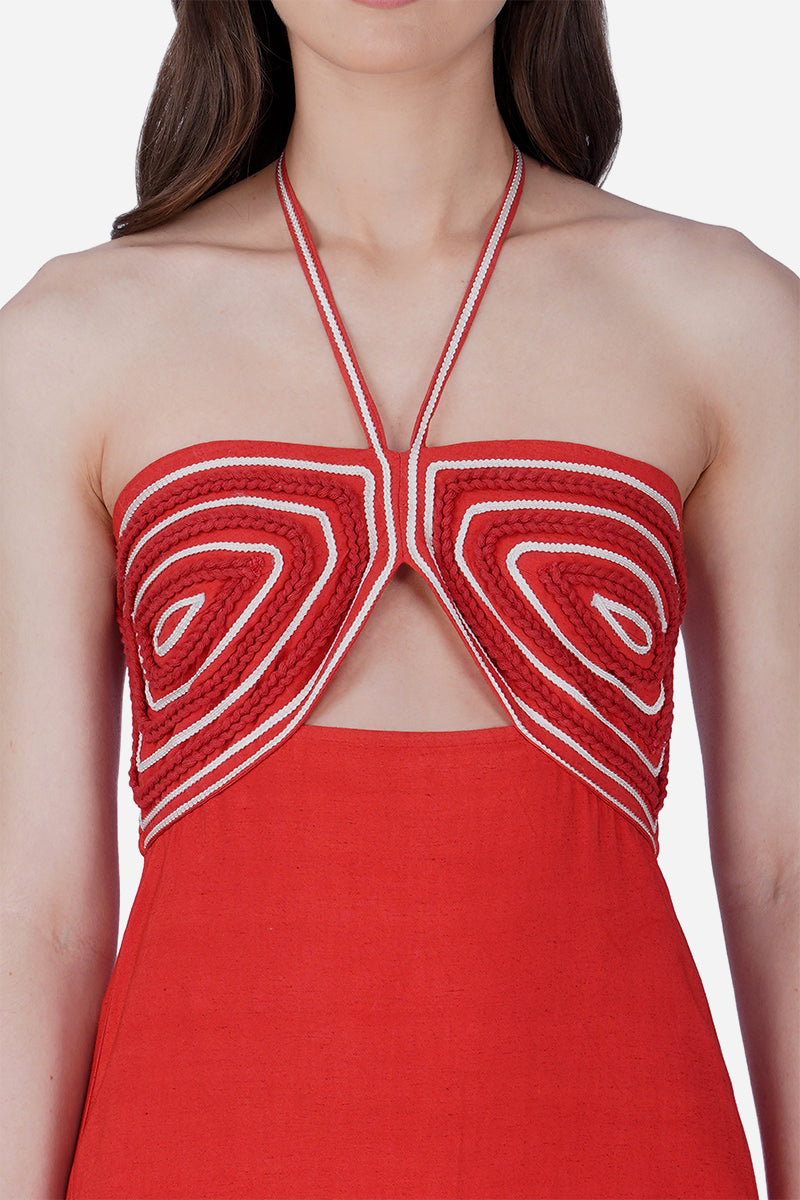 Red halter dress with white embroidery on a white background