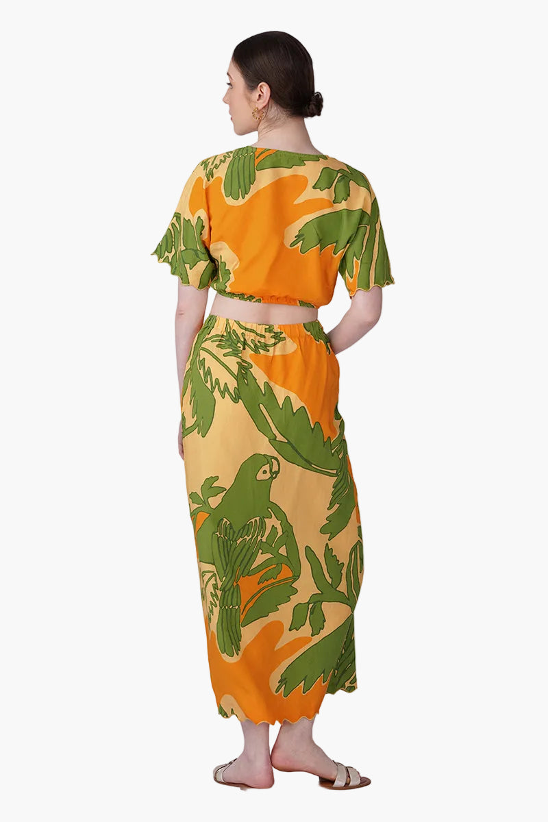 Woman wearing a tropical patterned outfit on a white background